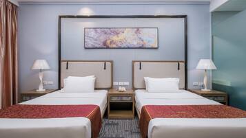 A hotel room with two beds, a large abstract painting on the wall, and a carpeted floor.