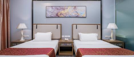 Una habitación de hotel con dos camas, un cuadro abstracto grande en la pared y piso alfombrado.