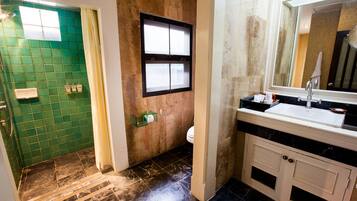 A bathroom with a green tiled wall, a white sink, and a mirror above it.