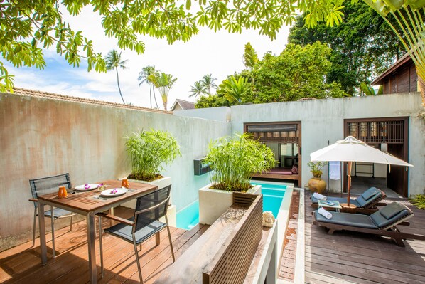 A wooden deck with a pool, lounge chairs, and a table with chairs. - Pao Jin Poon Beach Front Villa (Koh Samui)
