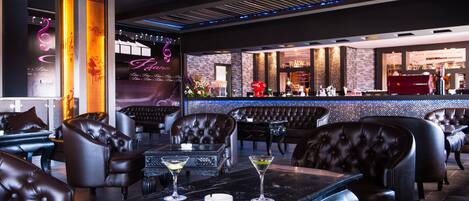 A modern bar area with leather seating, a neon sign, and a bar counter with various items.