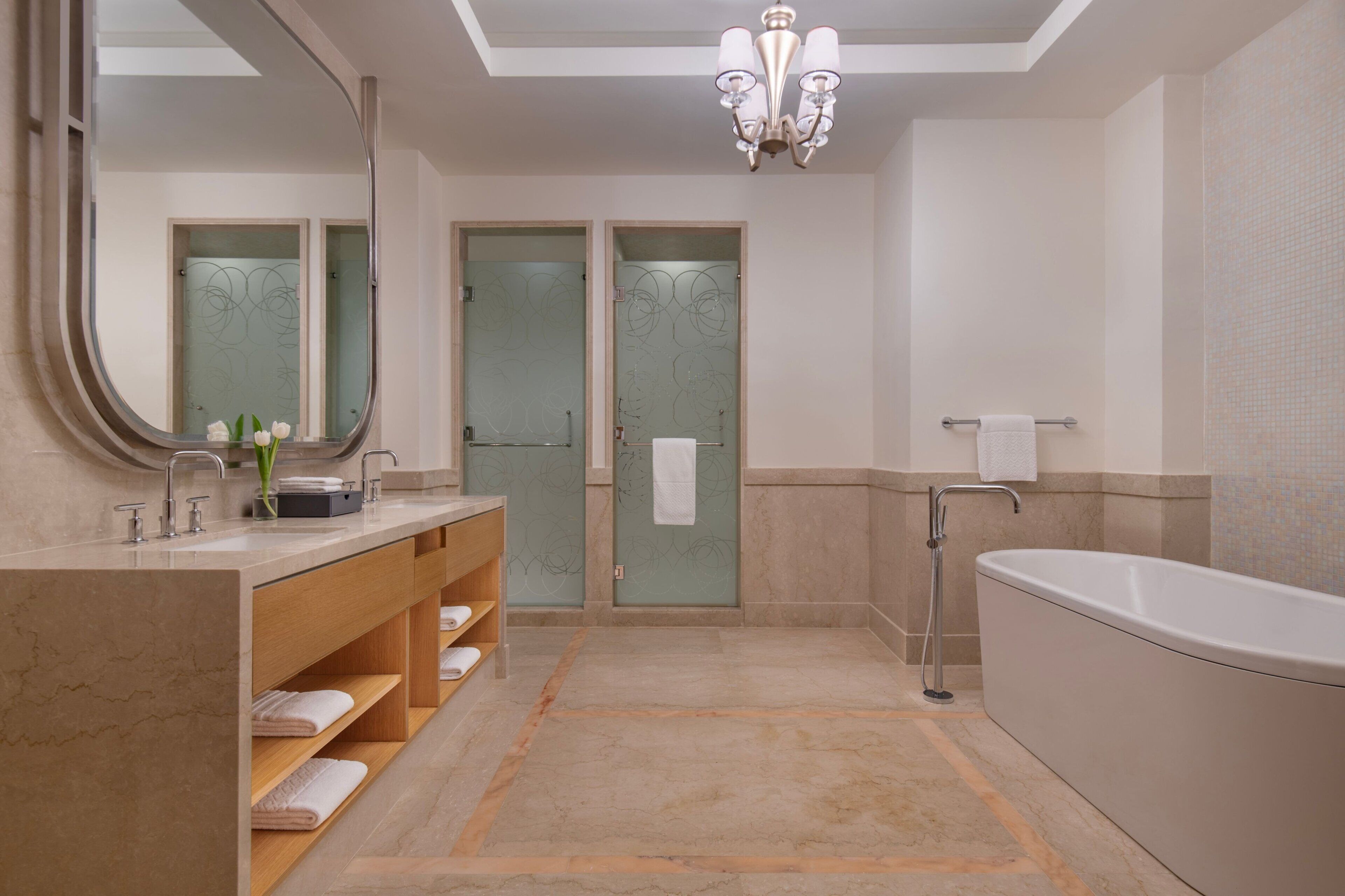 A modern bathroom with a large mirror, a bathtub, and a vanity with shelves.