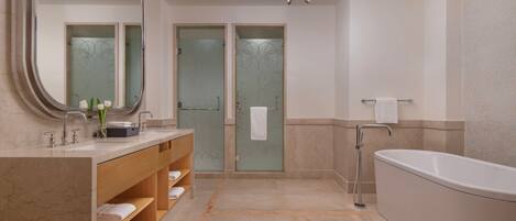 A modern bathroom with a large mirror, a bathtub, and a vanity with shelves.