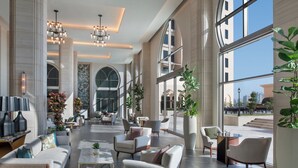 A spacious lobby with modern furniture, large windows, and a view of the city.