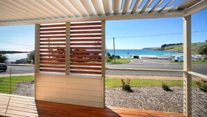 Un espacio al aire libre techado con vista al mar y a una carretera.