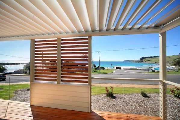 Espaço ao ar livre coberto com vista para o mar e uma estrada.
