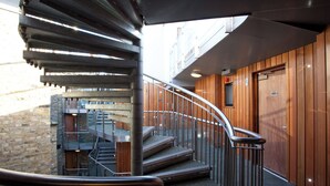 Eine moderne Treppe mit Metallgeländern, die zu einer oberen Ebene führt.