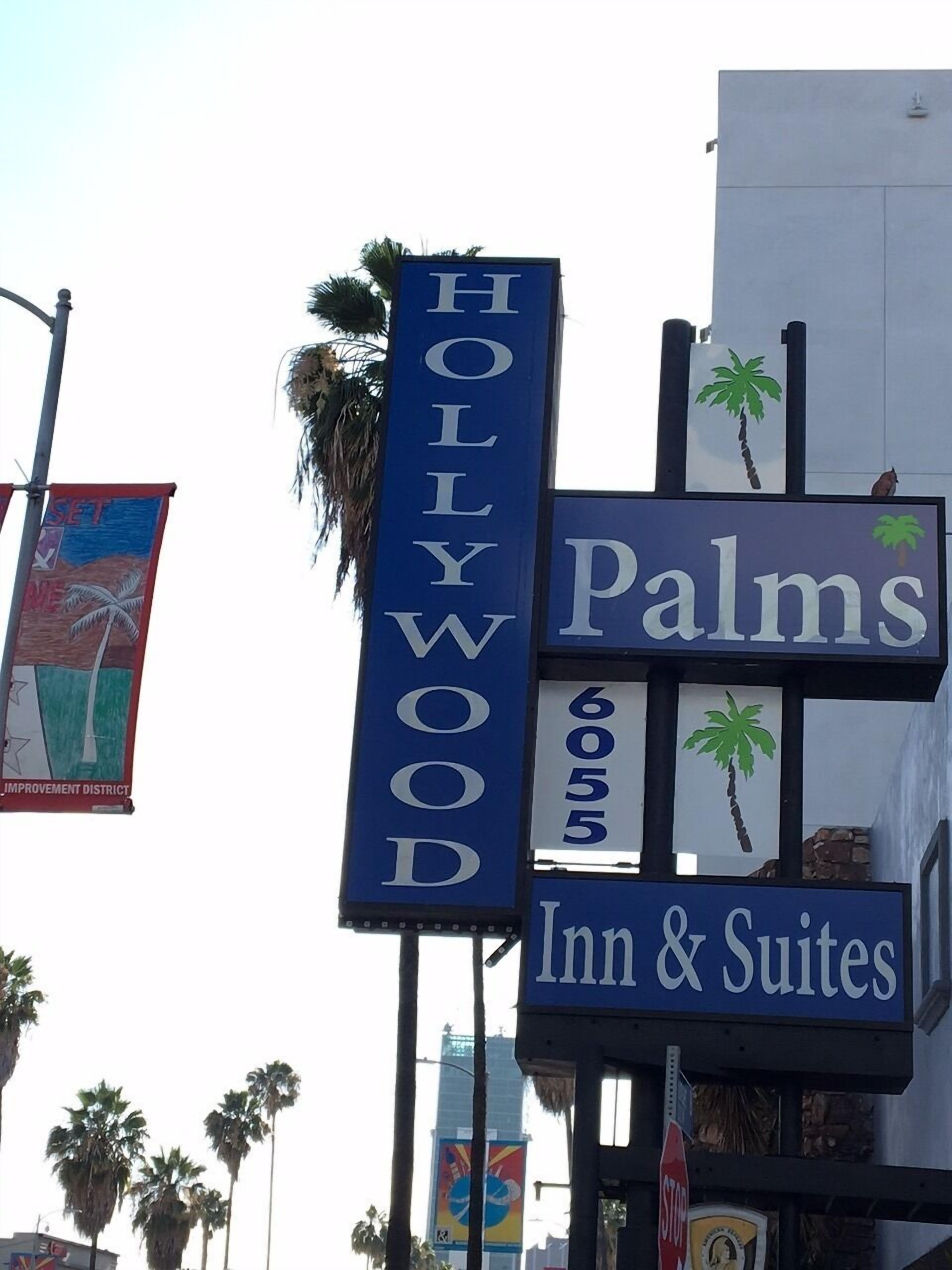 Une enseigne d’hôtel indiquant « Palms Inn & Suites » et l’adresse « 6055 Hollywood ».