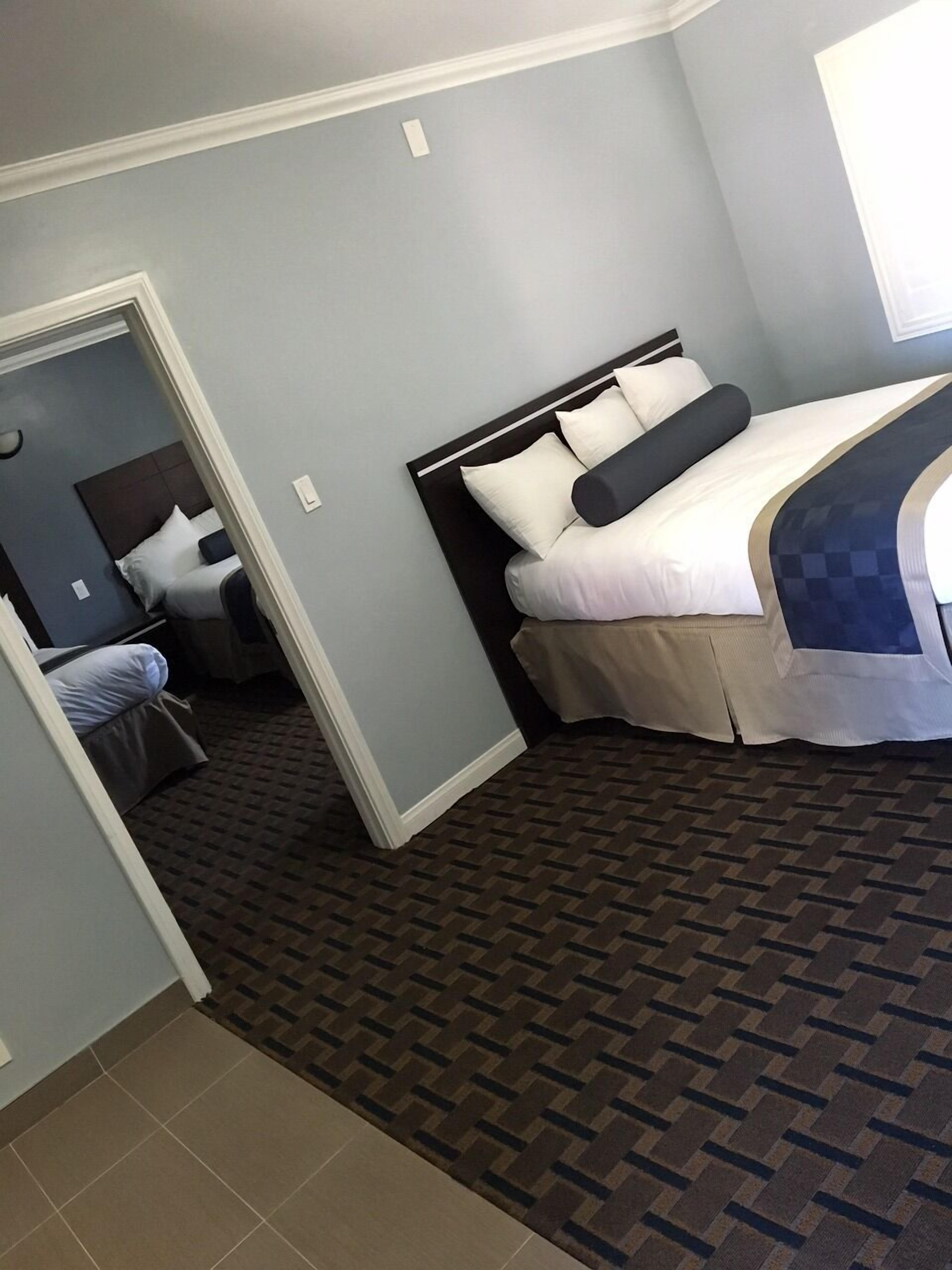 A hotel room with a bed, a nightstand, and a small desk.
