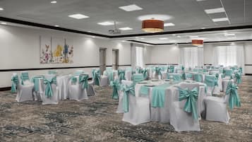 A conference room with tables and chairs, a carpeted floor, and a ceiling with recessed lighting.