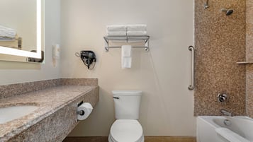 Un baño con inodoro, lavamanos, toallero y zona de ducha.