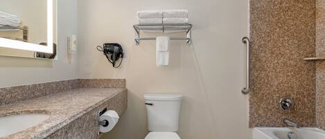 A bathroom with a toilet, sink, towel rack, and shower area.