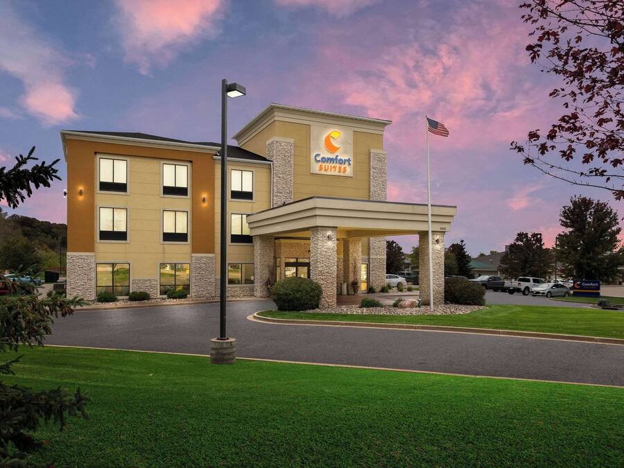 A Comfort Suites hotel with a stone facade, multiple windows, and a flag.