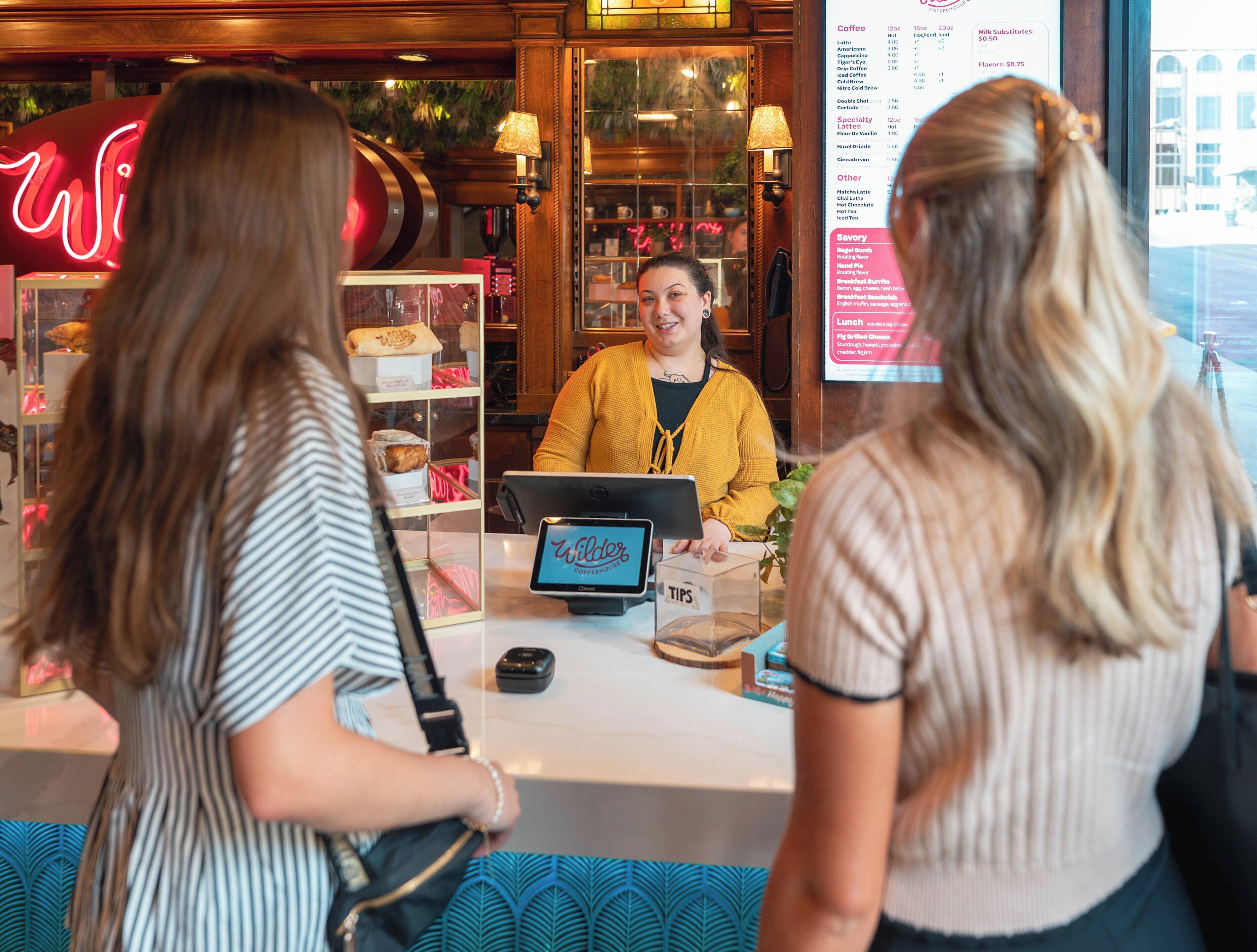 A coffee shop interior with a menu board, a counter, and a customer service area.