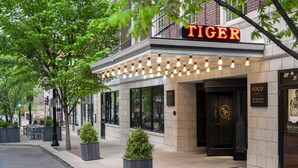 A theater with a marquee reading "TIGER" and a sign for "The Tiger Hotel."