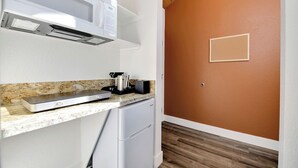 A compact kitchen with a microwave, toaster, and small refrigerator. - Amador Hotel (Pioneer)