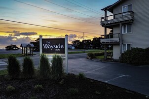 Un letrero de hotel con el nombre "The Wayside Inn" sobre un cielo al atardecer.