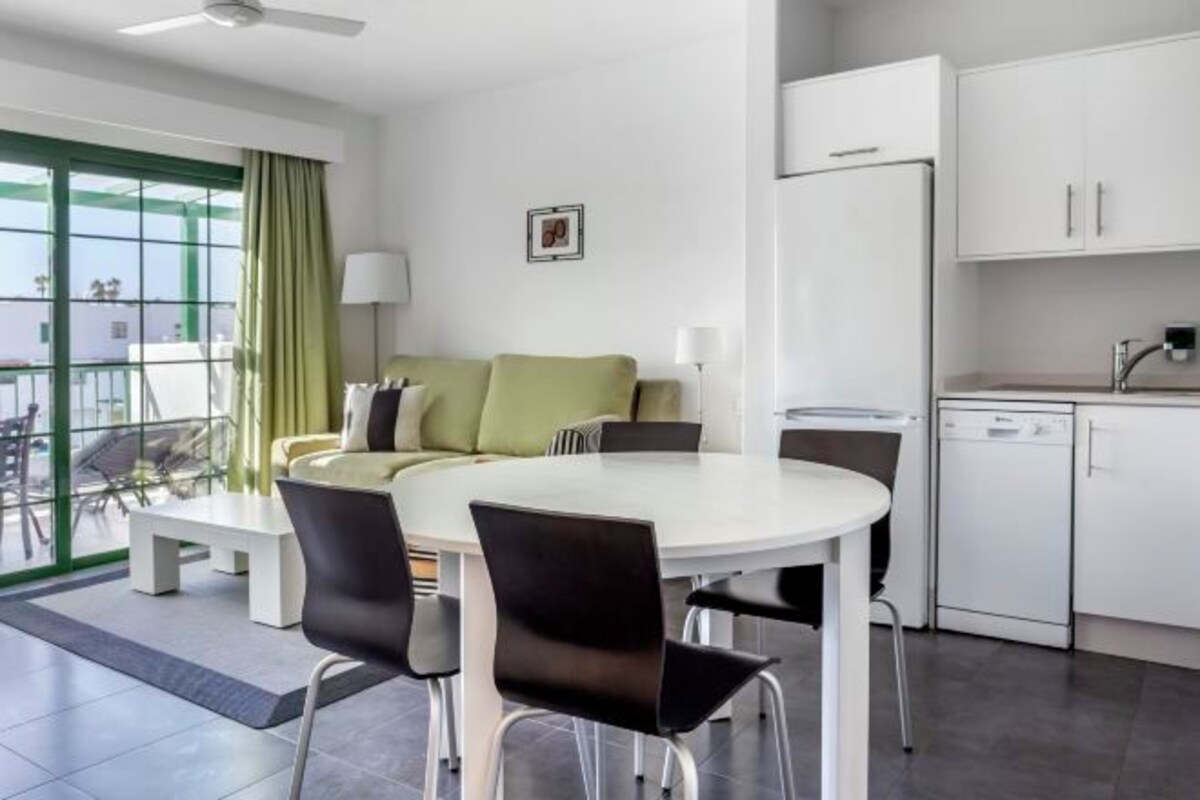 A modern kitchen with white cabinets, a white refrigerator, and a dishwasher.
