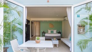 Un dormitorio pequeño con cama, mesitas de noche y una zona de estar.