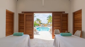 Una habitación con dos camas, vistas a una piscina y contraventanas de madera.