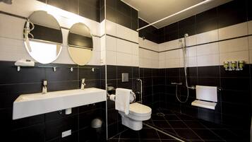 A modern bathroom with a white sink, two mirrors, a toilet, and a shower.