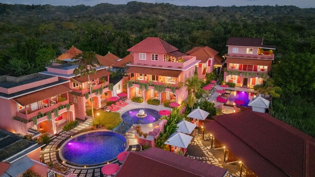 Un resort con varias edificaciones, piscina y un espacio exterior bien iluminado.