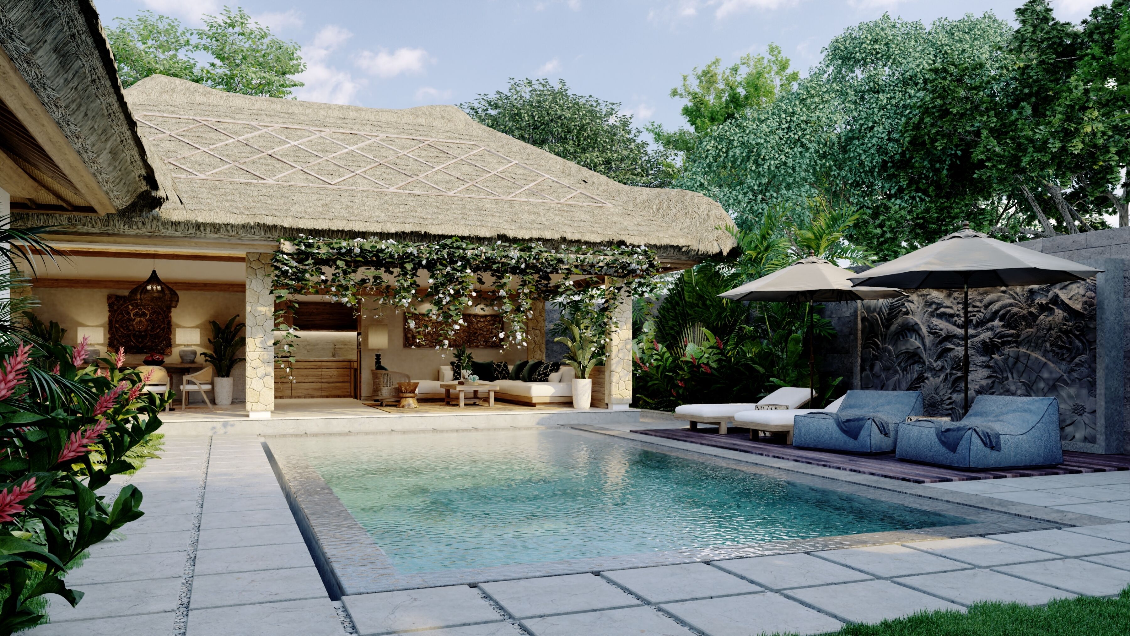 Zona junto a la piscina con una estructura de techo de paja, sillas de descanso y un muro de piedra con un relieve escultórico.