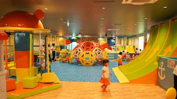 A children's play area with various play structures and soft play surfaces.