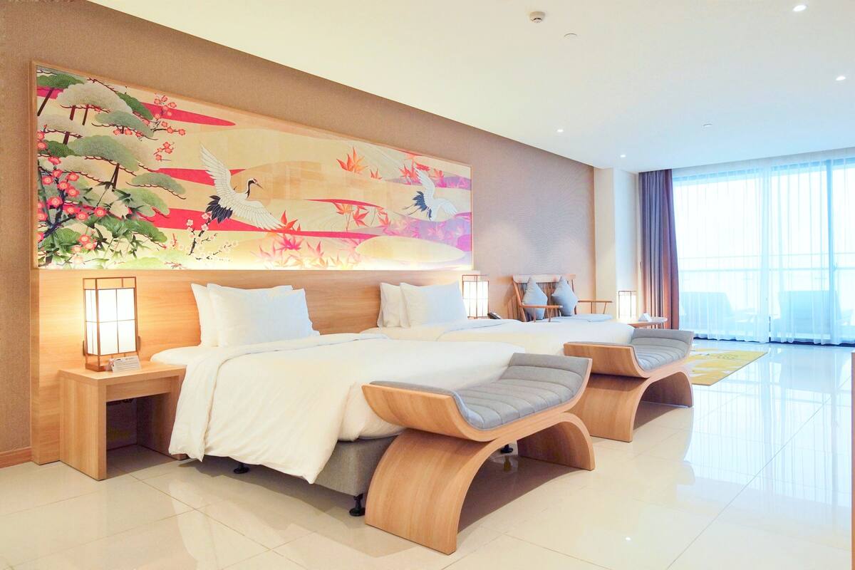 Een moderne hotelkamer met een groot bed, een bureau en een raam.