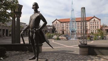 A statue in a public square with a building in the background.