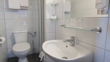 Un baño con inodoro, lavabo y ducha.