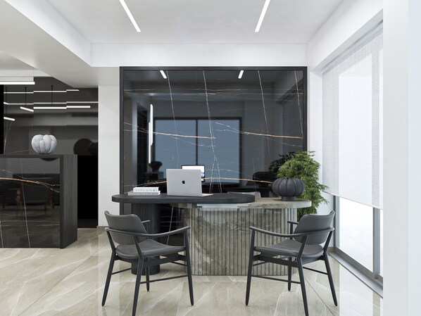 A modern office space with a glass partition, two chairs, a laptop, and a potted plant. - Porto Platanias Beach - Luxury Selection (Chania)