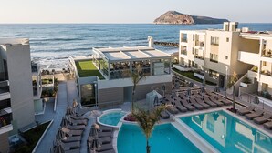 A rooftop pool area with lounge chairs and a view of the sea.
