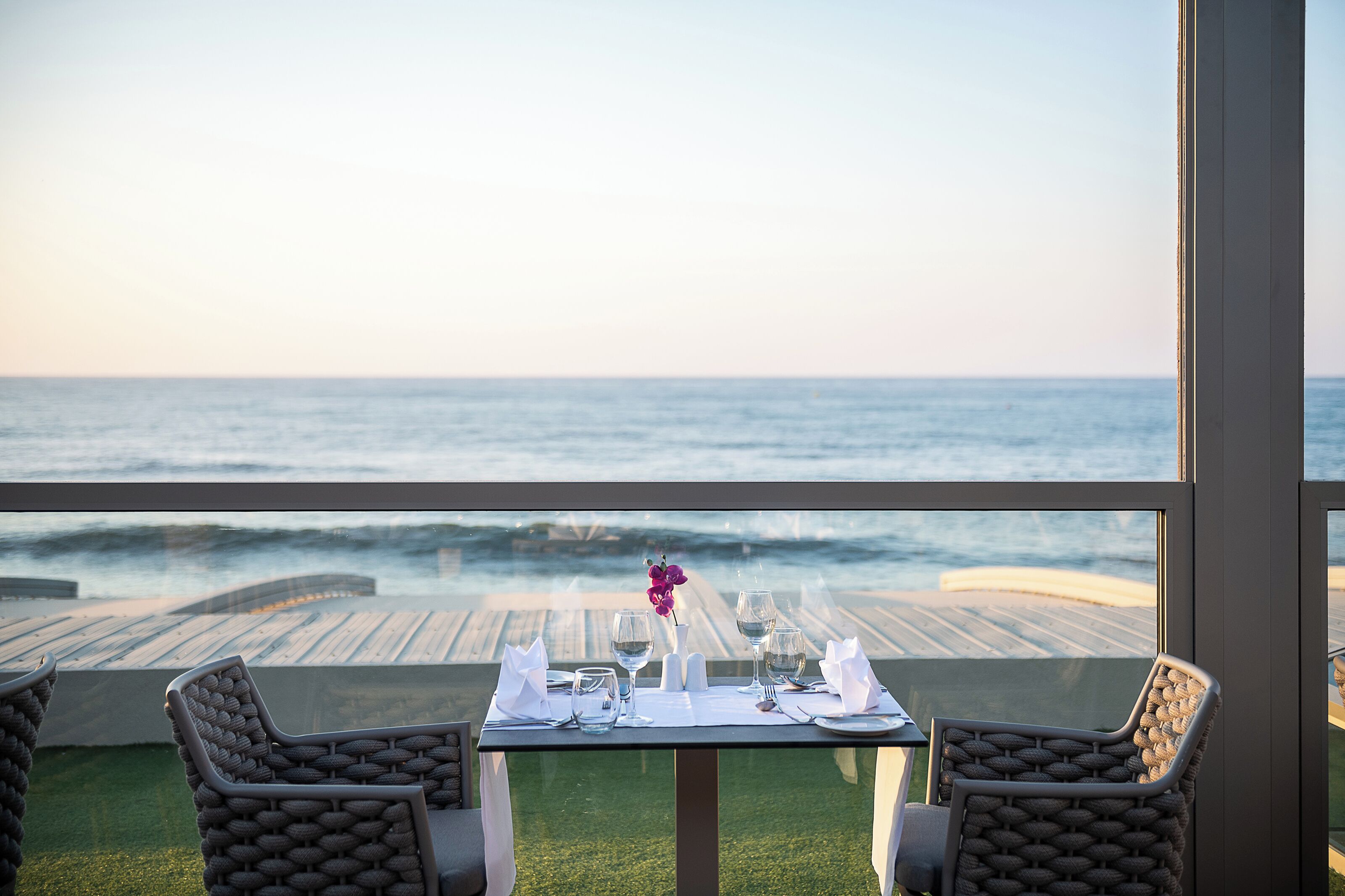 A table set for two with a view of the ocean.