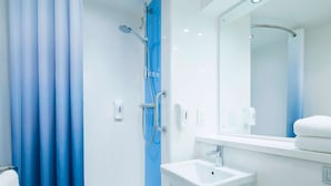 Un baño moderno con ducha, lavabo y espejo.