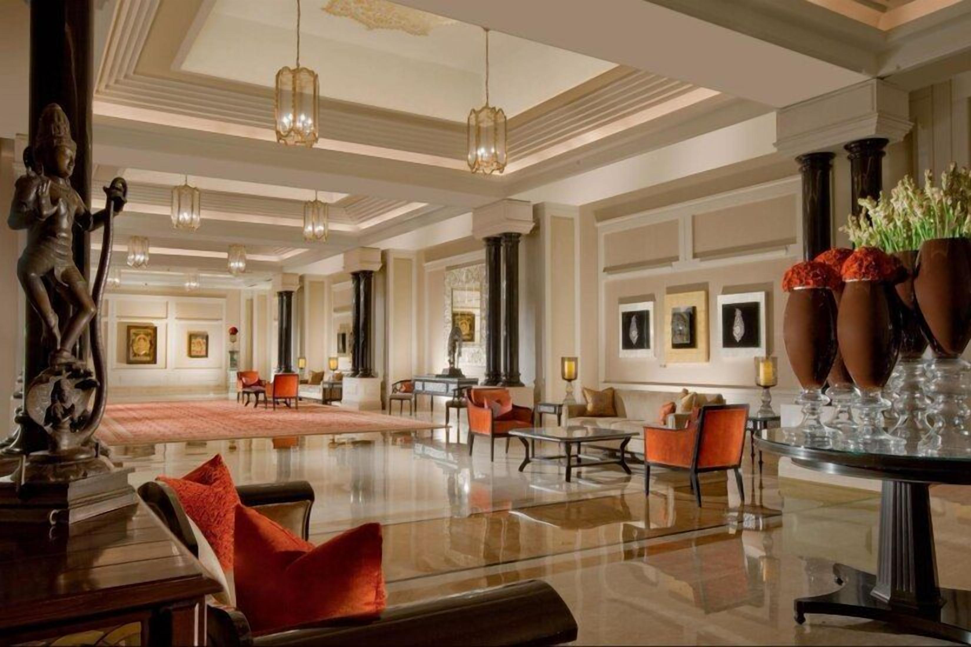 A spacious lobby with a polished floor, seating areas, and a statue.
