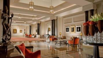 A spacious lobby with a polished floor, seating areas, and a statue.