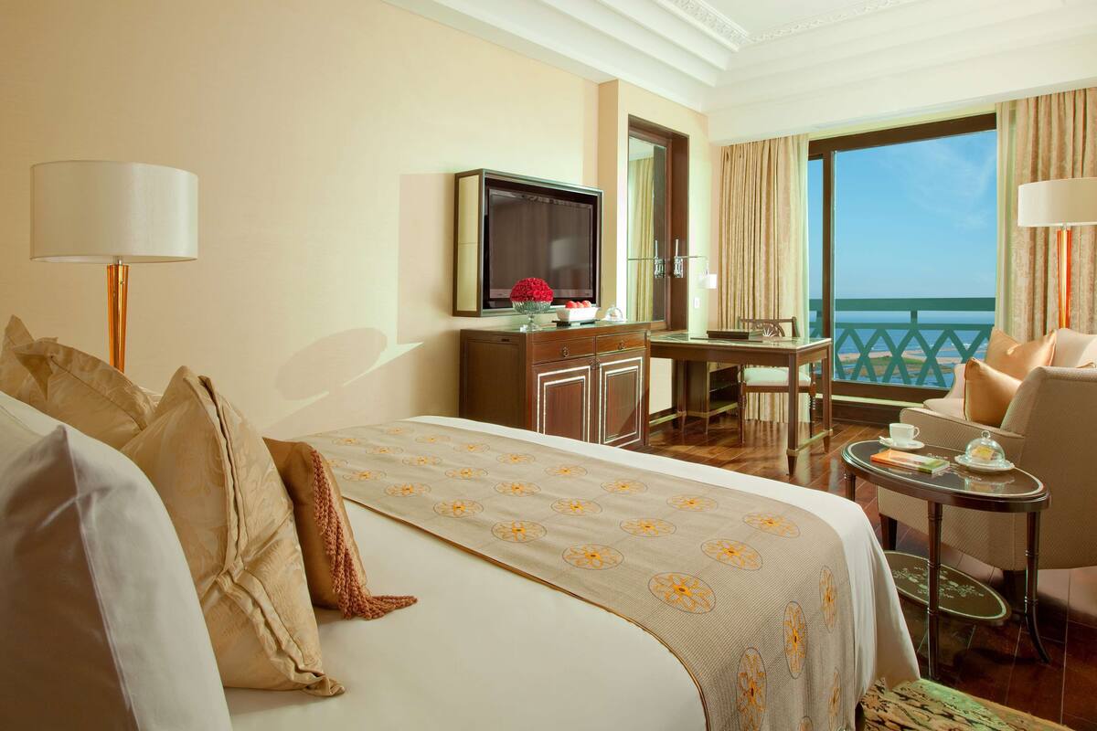 Ein Hotelzimmer mit Bett, Schreibtisch, Fernseher und Meerblick.