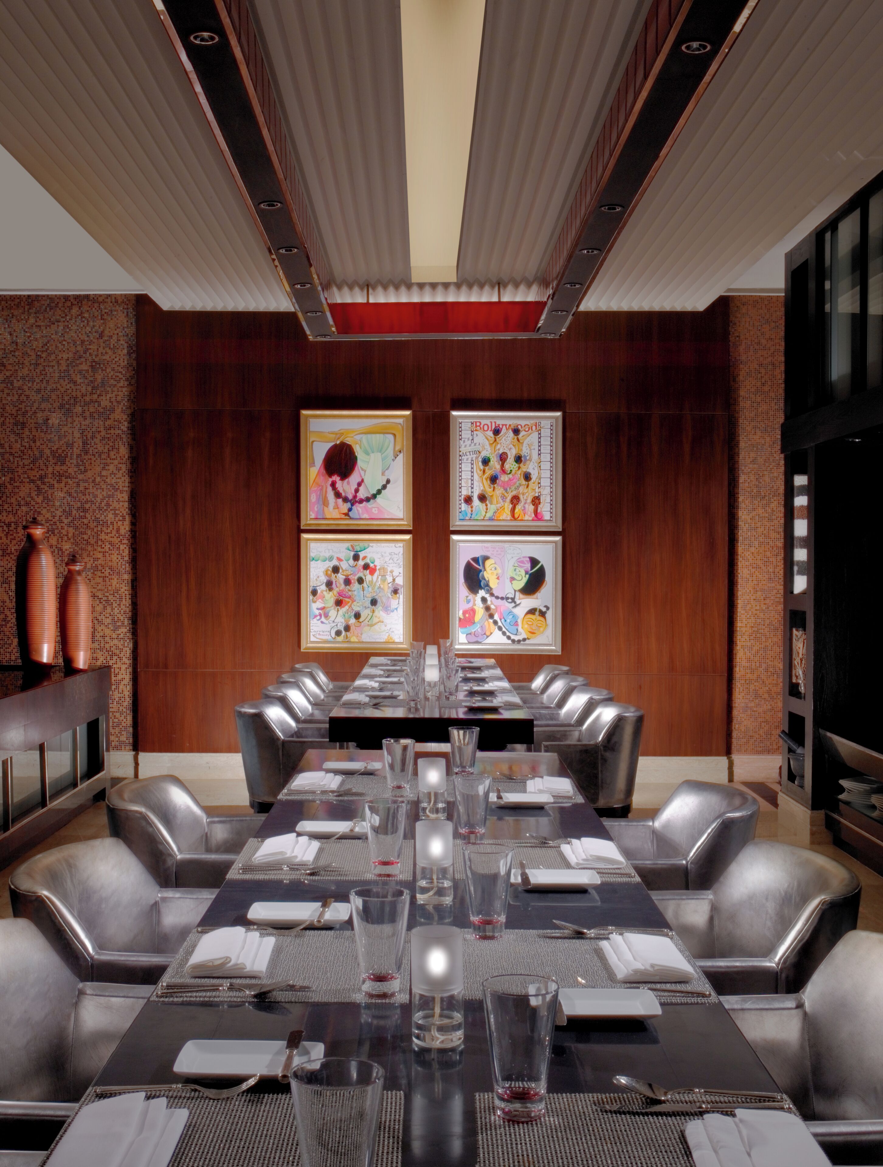 A conference room with a long table, multiple chairs, and artwork on the walls.