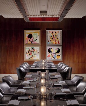 A conference room with a long table, black leather chairs, and framed artwork on the walls. - The Leela Palace Chennai (Chennai)