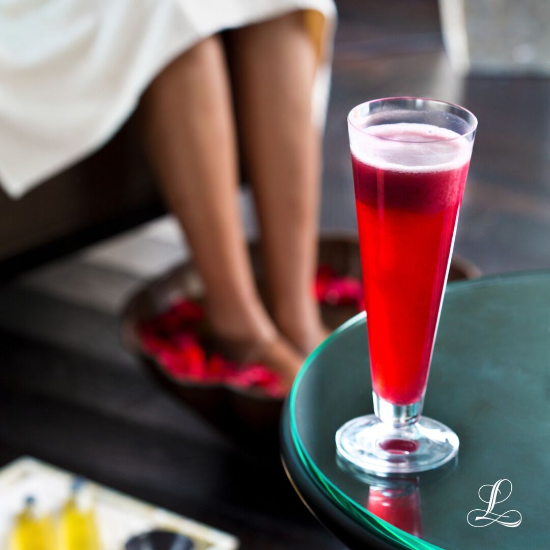 Un verre d’une boisson rouge posé sur une surface réfléchissante.