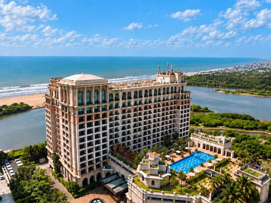 Un hotel grande con varios pisos, piscina y vista al océano.