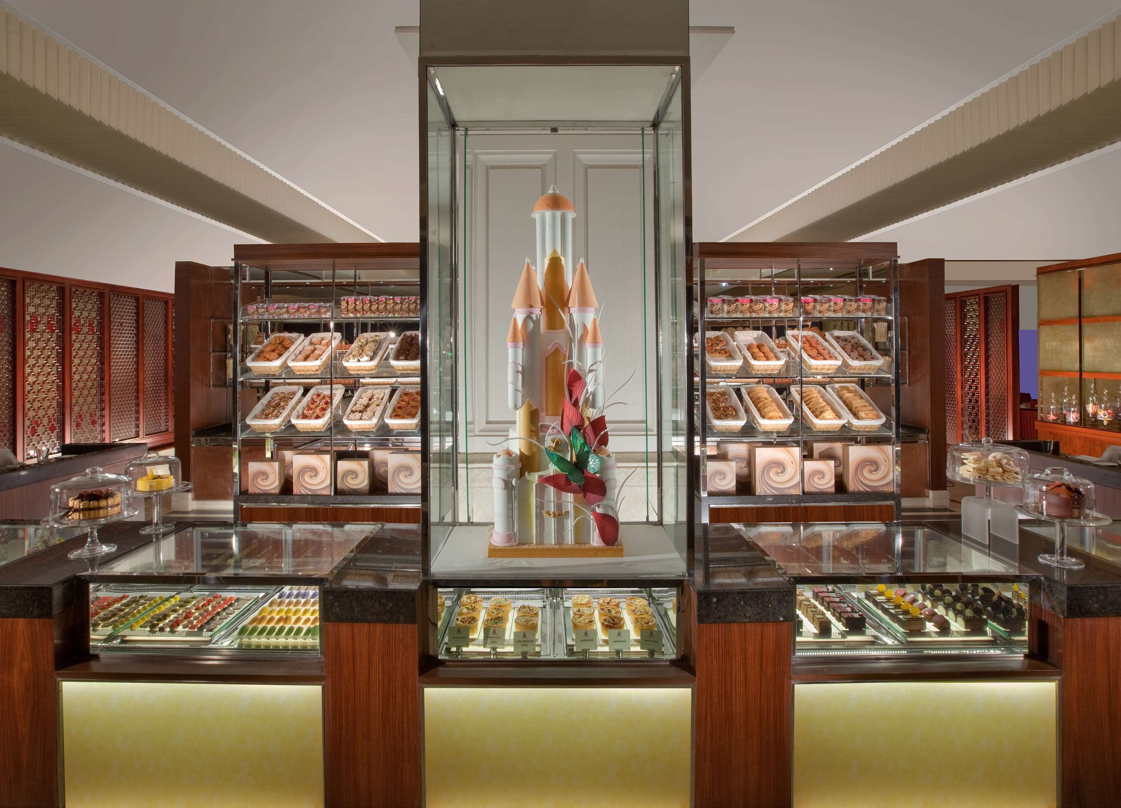 A bakery display with various pastries and desserts in a well-lit, modern interior.