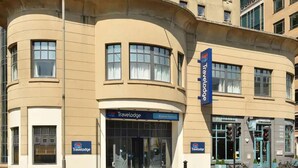 A Travelodge hotel with a curved facade, large windows, and a sign indicating it is located at Brighton Seafront. - Travelodge Brighton Seafront (Brighton)