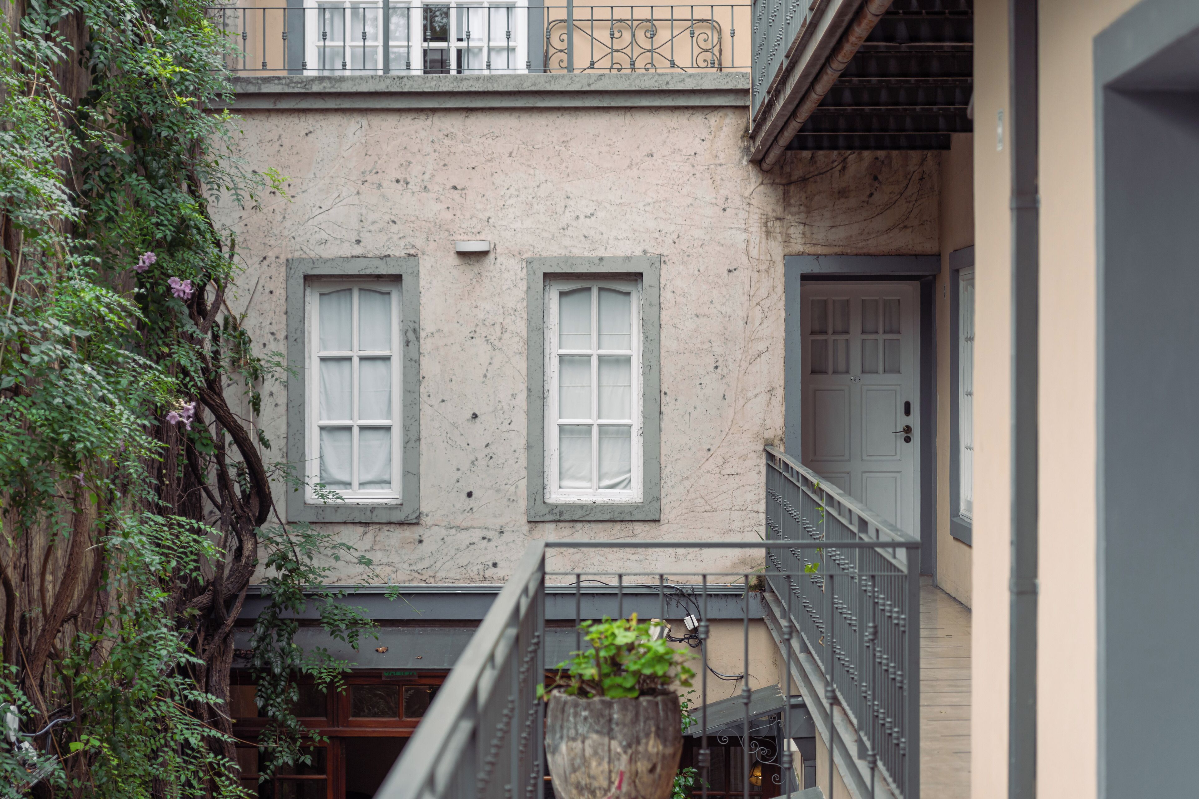 Una estrecha calle urbana con edificios que tienen grandes ventanales y balcones.