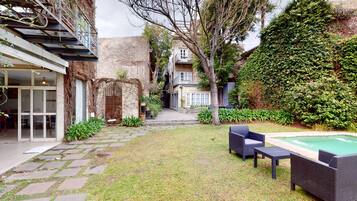 Una piscina al aire libre, sillones reclinables de piscina