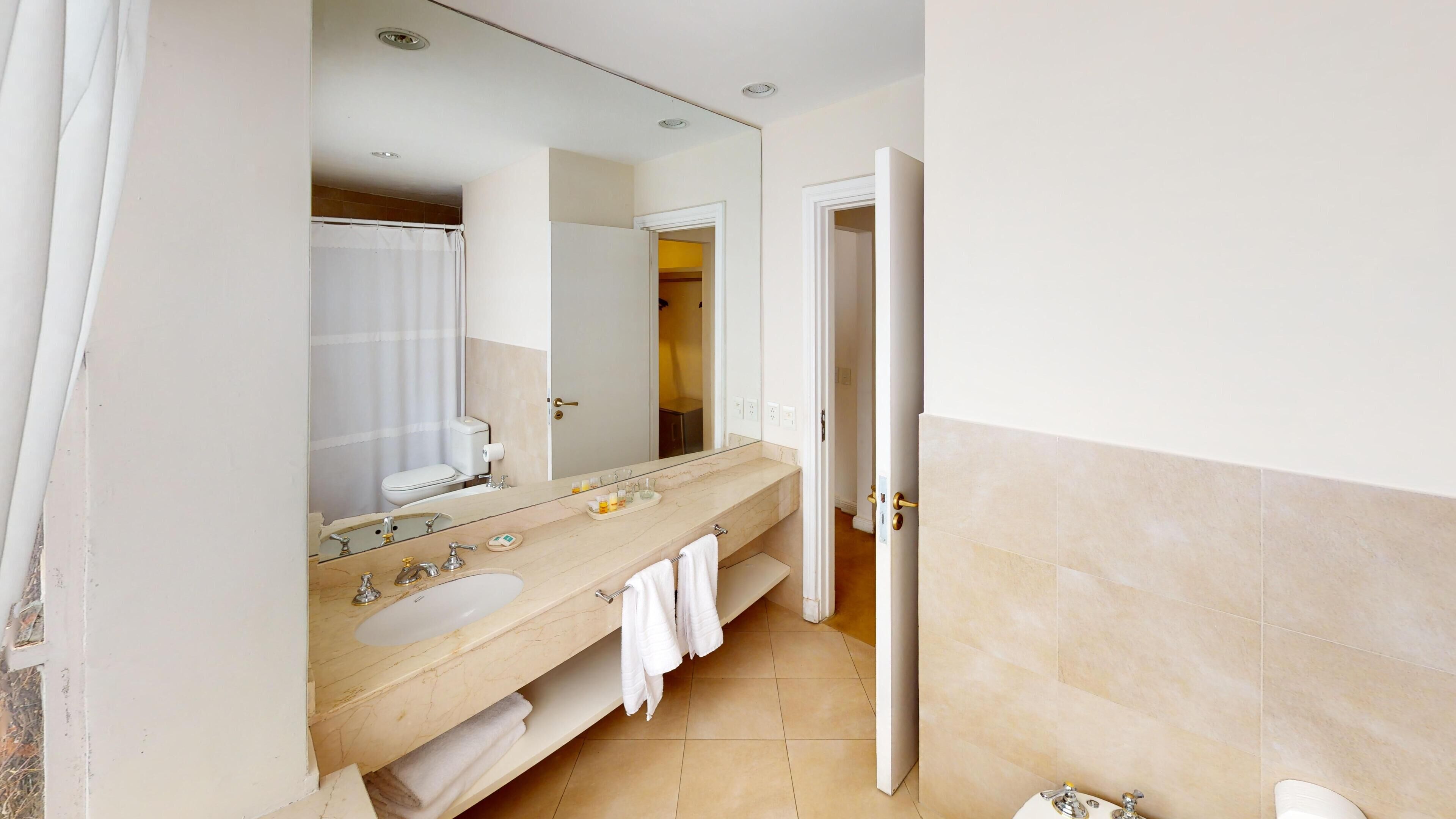 suite, garden view | bathroom | combined shower/bathtub, deep-soaking bathtub, rainfall showerhead