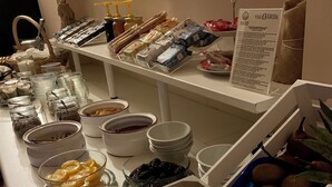 Un bufé con diversas opciones de comida, incluyendo frutas, quesos y salsas.