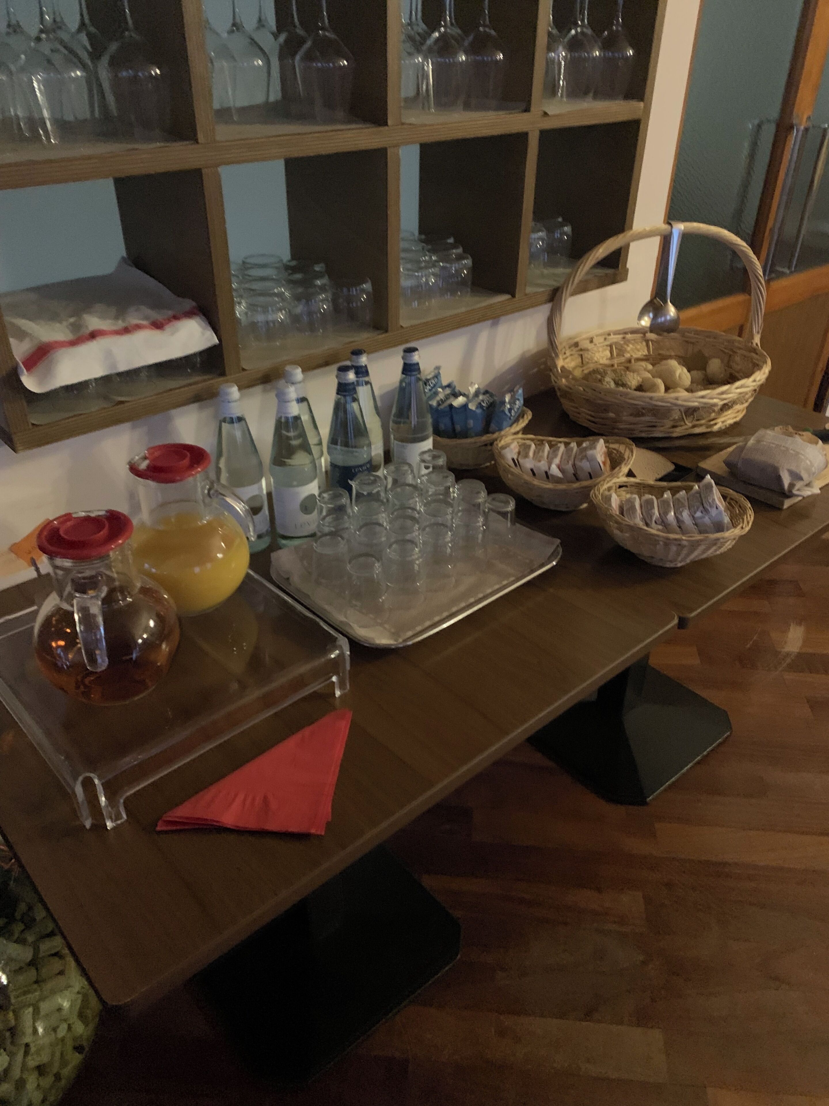 A table with various items including bottles, glasses, and baskets, likely set up for a gathering or event.