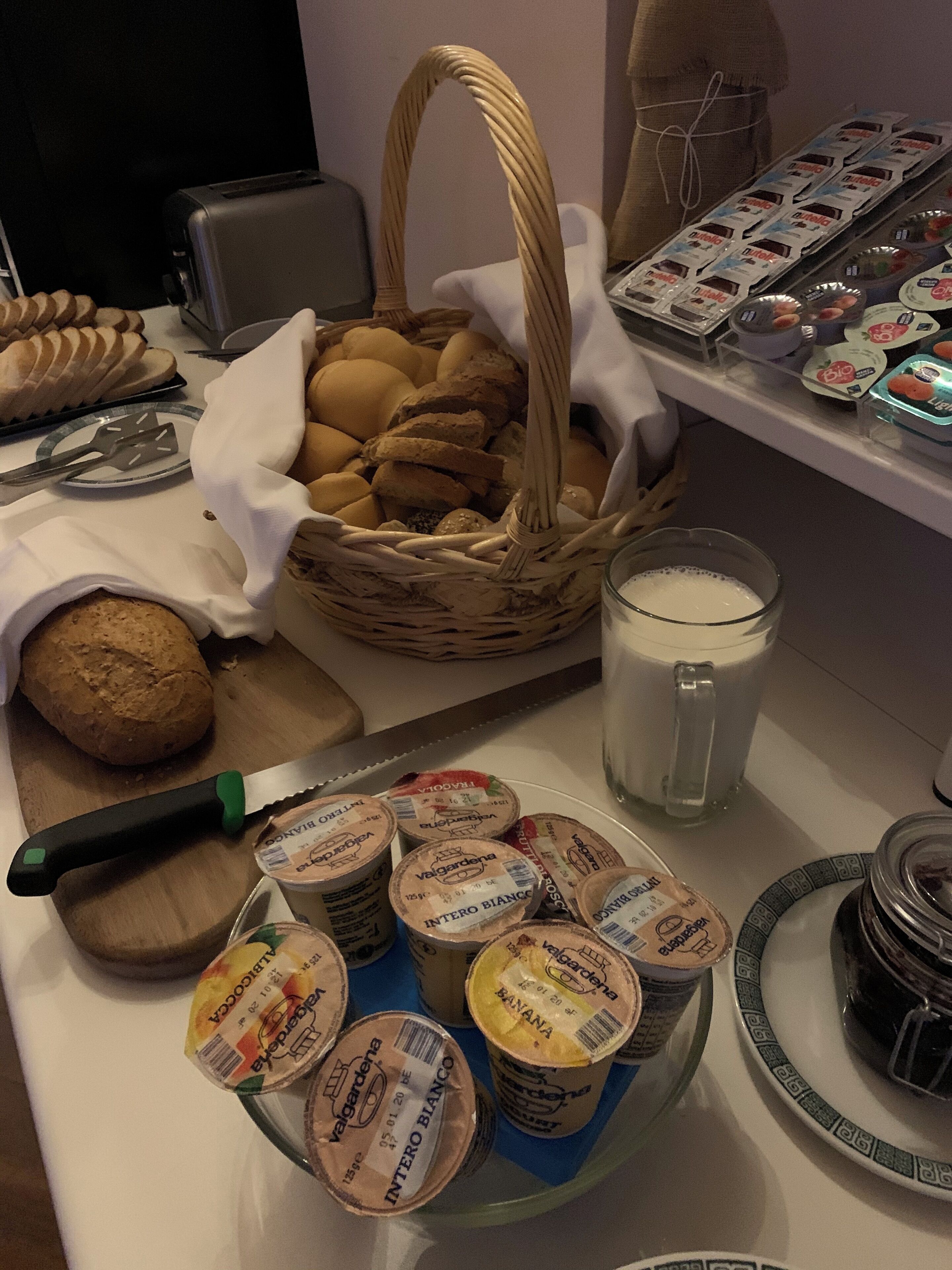 Een ontbijtbuffet met verschillende broden, gebak en zuivelproducten.